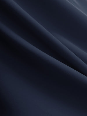 Close-up texture of navy flat front golf joggers pants with belt loops fabric showing detailed material and weave.