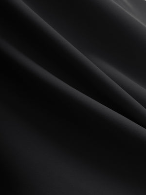 Close-up texture of black flat front golf joggers pants with belt loops fabric showing detailed material and weave.