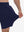 View showing loose fit of navy breathable running shorts with 4 zipper pockets