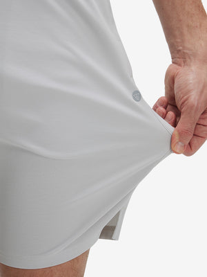 View showing loose fit of khaki grey breathable running shorts with 4 zipper pockets