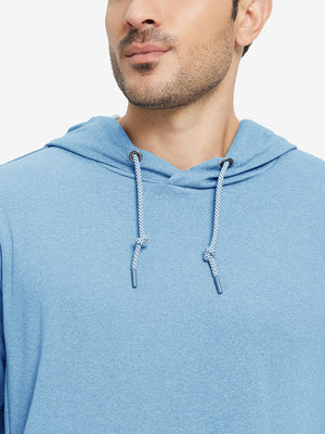 Close-up from nose to chest, showing soft heather texture and collar detail of the light blue melange hoodie.