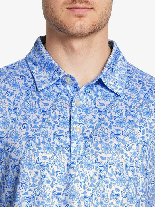 The model wears the WHITE PAISLEY golf polo shirt, seen from the chest, highlighting its cut and comfort