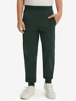 Model wearing forest green fleece stretch water resistant boys joggers, front view showing lower body and pants.