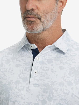Close-up from nose to chest, showing collar and fabric pattern detail of the gray ink splash polo shirt.