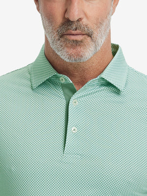 Close-up from nose to chest, showing collar and fabric pattern detail of the green plant polo shirt.
