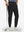 Front lower body shot of model wearing black flat front golf joggers pants with belt loops