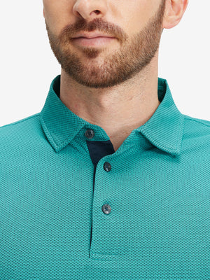 Close-up of a model wearing the turquoise feather weight jacquard polo shirts, focusing on the collar and face