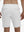 Back lower body shot of model wearing white breathable running shorts with 4 zipper pockets