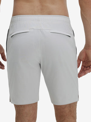 Back lower body shot of model wearing khaki grey breathable running shorts with 4 zipper pockets