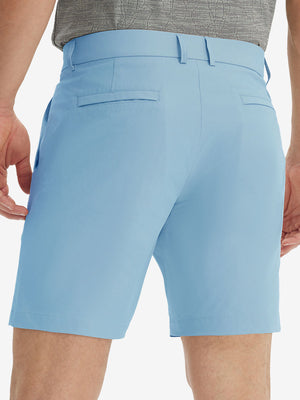 Back lower body view of model wearing the light blue stretch soft flat front dress golf shorts, highlighting the rear design