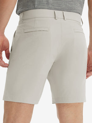 Back lower body view of model wearing the light khaki stretch soft flat front dress golf shorts, highlighting the rear design