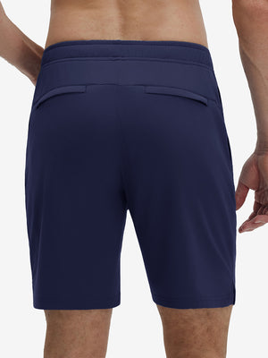 Back lower body shot of model wearing navy breathable running shorts with 4 zipper pockets
