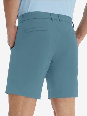 Back lower body view of model wearing the blue stretch soft flat front dress golf shorts, highlighting the rear design