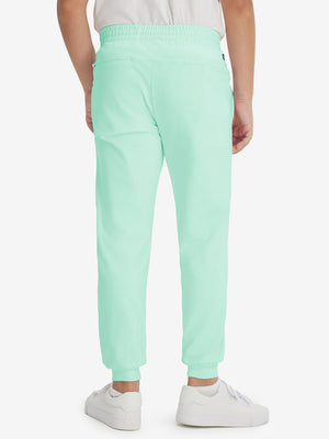 Model's lower body from the back, wearing turquoise fleece stretch water resistant boys joggers.