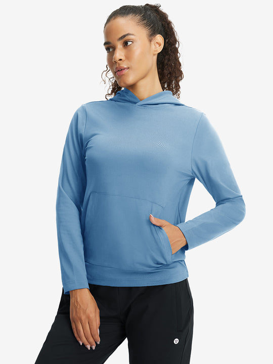 Model with one hand in side pocket wearing women's lightweight hoodies pullover in misty blue.