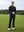 Model in black long sleeve solid jersey polo holding a golf club outdoors, full-body shot