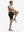 Front full body shot of model exercising in black breathable running shorts with 4 zipper pockets
