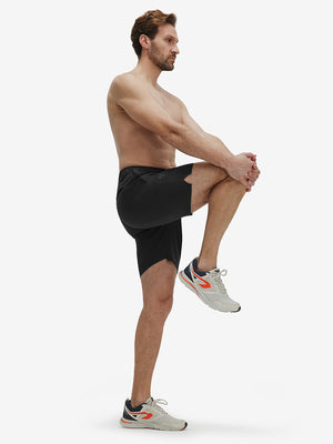 Front full body shot of model exercising in black breathable running shorts with 4 zipper pockets