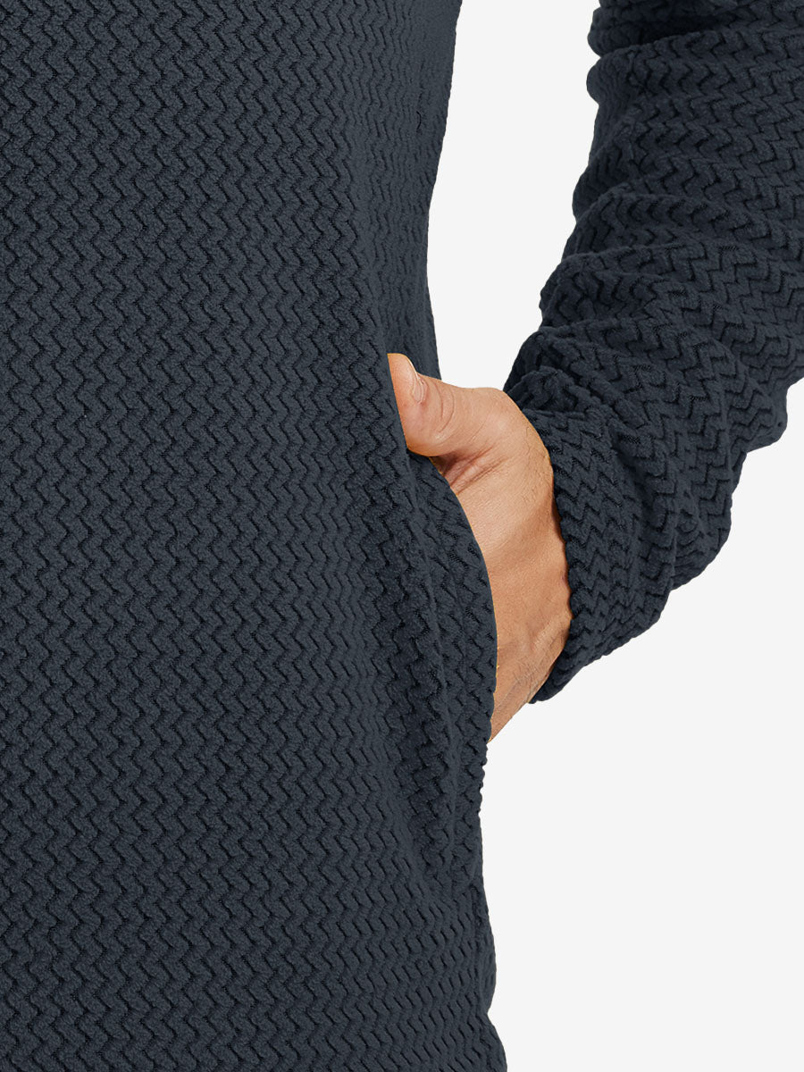 Close-up of pocket detail on midweight warm stretchy quarter zip pullover in navy, showing neat stitching.