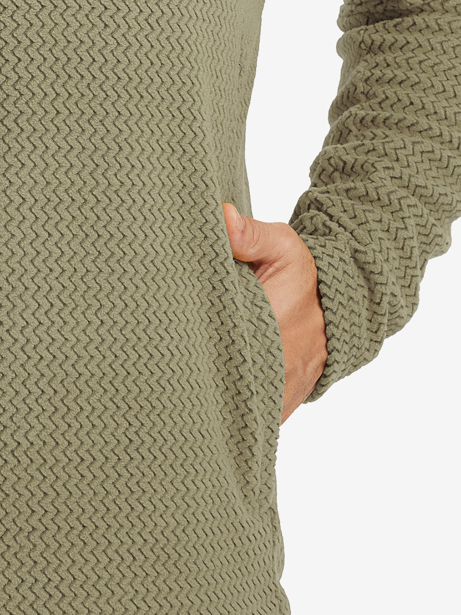Close-up of pocket detail on midweight warm stretchy quarter zip pullover in desert yellow, showing neat stitching.