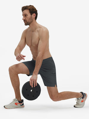 Front full body shot of model exercising in dark grey breathable running shorts with 4 zipper pockets