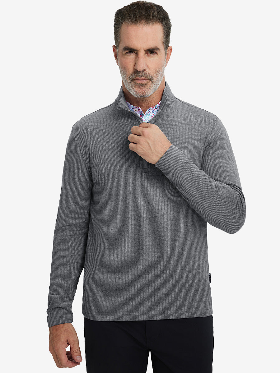 Model grabbing half-zip collar, wearing casual fleece lined quarter zip pullover in grey.