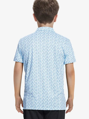 Back half-body view of boy wearing BLUE DINOSAUR Performance Print Boys Golf Polo outdoors