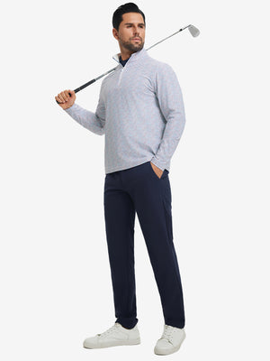 Full-body shot of model holding golf club, dressed in full print quarter zip pullover in colorful hexagon.