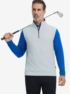 Model holding golf club, wearing print collar quarter zip golf vest in misty grey, upper body view.
