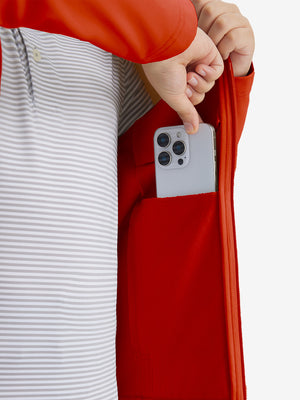 Close-up of the front side pocket detail on kids soft lightweight fleece lined jacket in orange, showing quality stitching.