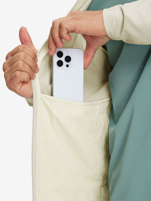 Hand placing iPhone into inner pocket of lightweight water-resistant outerwear jacket in khaki