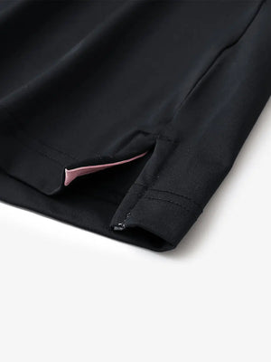Hem slit detail of BLACK Moisture Wicking Color Block Polo Shirt highlighting stitching and finish.