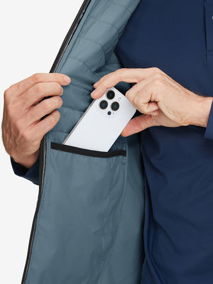 Inner pocket detail of Lightweight Water Resistant Puffer Vest in slate blue, holding smartphone