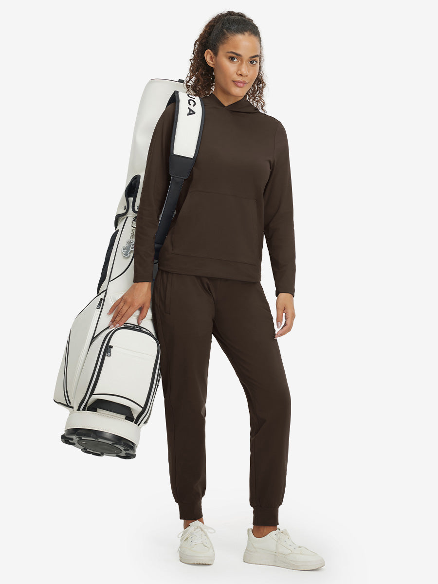 Model carrying golf bag, wearing women's lightweight hoodies pullover in coffee brown.
