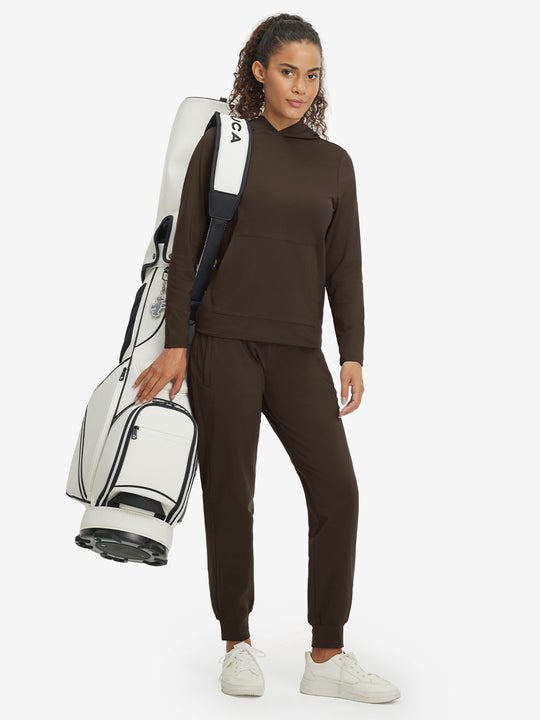 Model carrying golf bag, wearing women's lightweight hoodies pullover in coffee brown.
