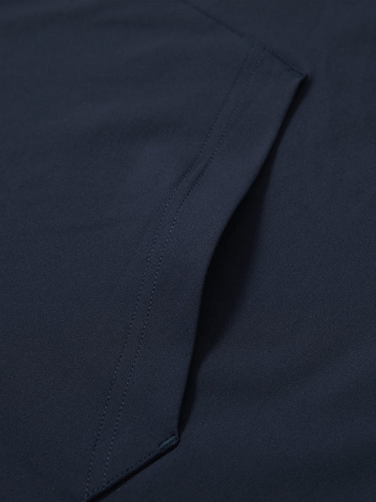 Close-up of single pocket detail on youth long sleeve hoodied with kangaroo pocket in navy, showing stitching.