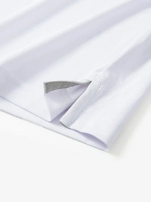 Detail view of the white long sleeve pique polo, highlighting the hem opening and clean design.
