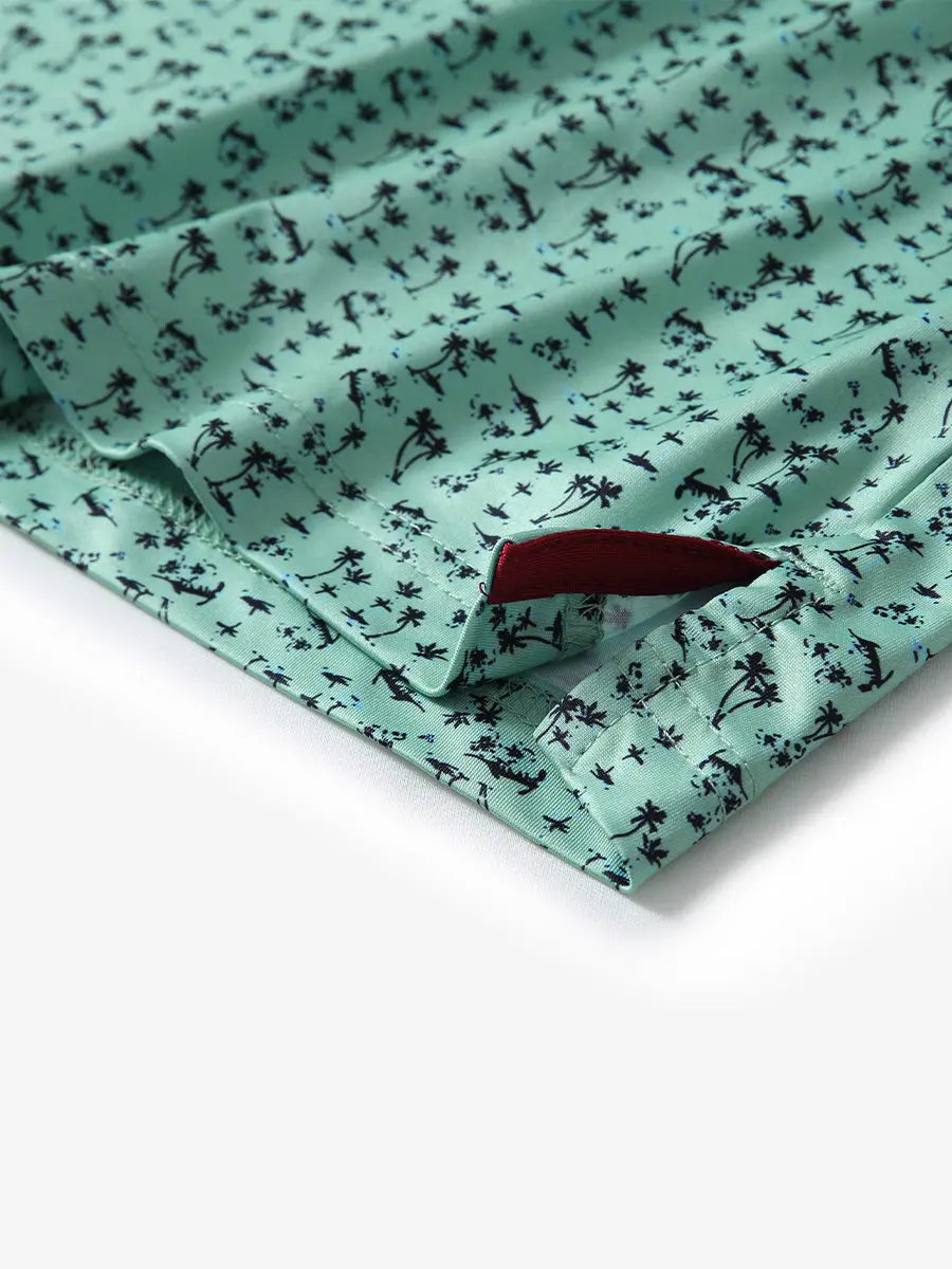 Detail view of the mint seaside palm pattern polo shirt, focusing on the neat hem opening and refreshing design.