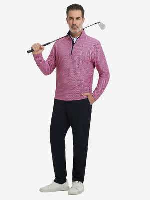 Full-body shot of model holding golf club, dressed in full print quarter zip pullover in red navy flower.
