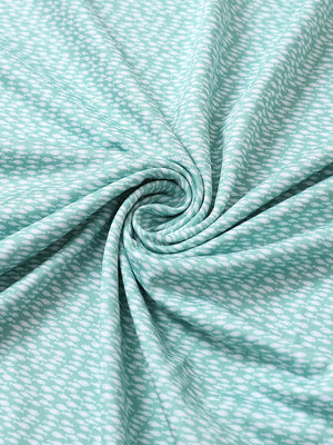 Close-up of green white fish performance jersey print polo fabric showing breathable texture.