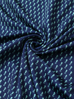 Close-up of green seahorse performance print boys golf polo fabric showing moisture-wicking texture and vibrant pattern.
