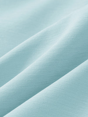 Close-up texture of light blue flat front hybrid golf shorts fabric showing detailed hybrid material and weave.