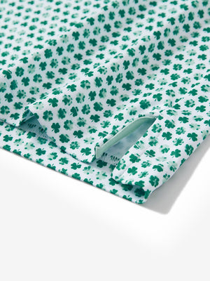Close-up of the hem vent on the green lucky clover 4 way stretch print collared polo shirt, showing the side split for movement