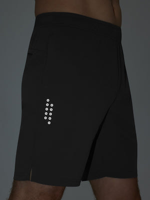 Detail of glow in the dark feature on black breathable running shorts with 4 zipper pockets