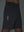 Detail of glow in the dark feature on dark grey breathable running shorts with 4 zipper pockets