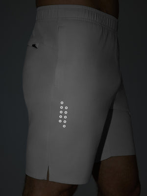 Detail of glow in the dark feature on khaki grey breathable running shorts with 4 zipper pockets