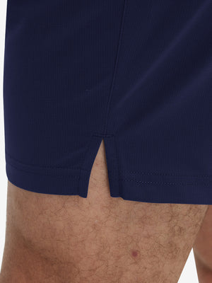 Detail view of hem on navy breathable running shorts with 4 zipper pockets