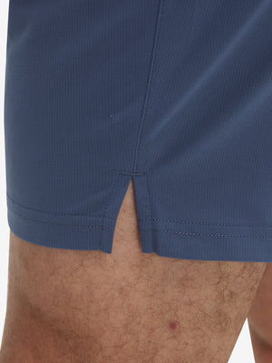 Detail view of hem on misty blue breathable running shorts with 4 zipper pockets