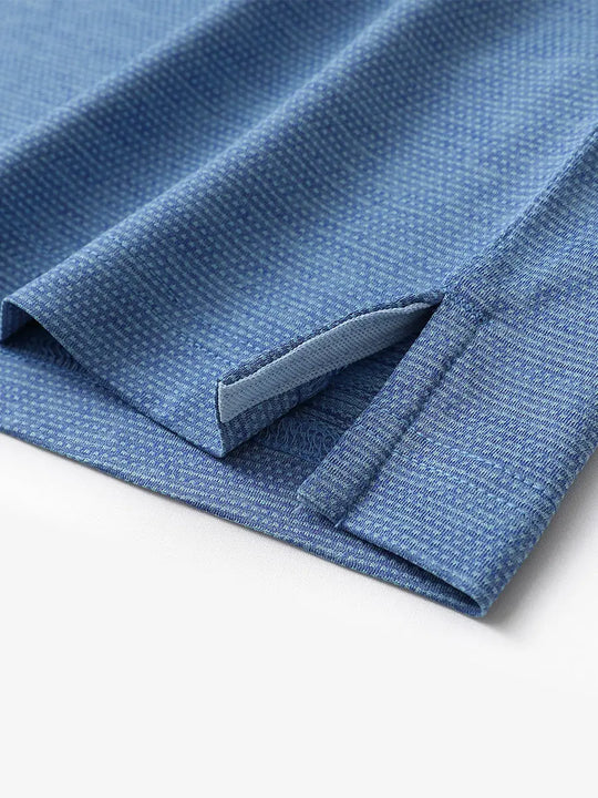 Close-up of side hem slit on Ventilated Heather Jacquard Polo in CLASSIC BLUE, showing detail