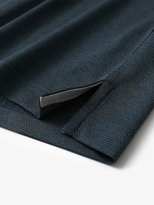 Close-up of side hem slit on Ventilated Heather Jacquard Polo in JUNGLE GREEN HEATHER, showing detail
